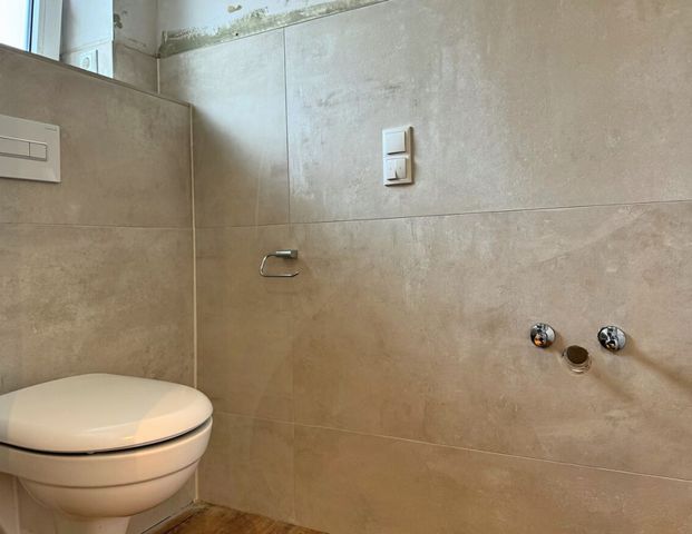 Erstbezug: Moderne Bungalowhälfte mit Einbauküche & Carport in ruhiger Siedlungslage von Wiesmoor - Foto 1