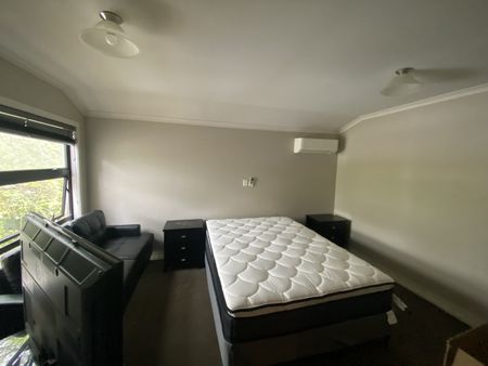 Furnished studio room featuring essential amenities such as a bed, TV, bar fridge, microwave, and heat pump. - Photo 4
