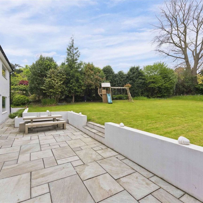 A truly impressive family home in a popular residential road in Esher, offering stylish and modern living with 5 bedrooms, 3 bathrooms and 4 reception areas. - Photo 1