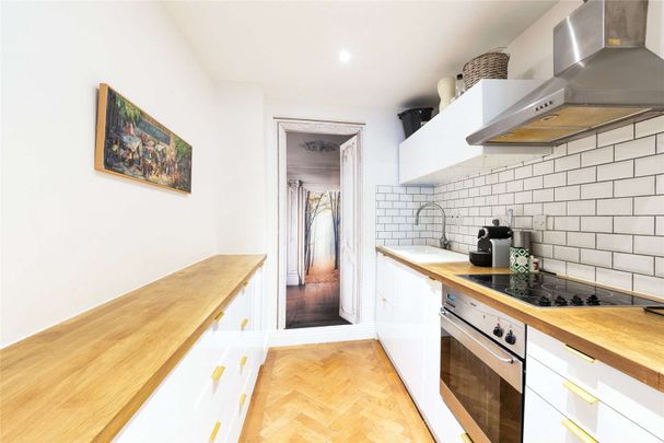 Set in a prime riverside location, this welcoming 1 bed flat offers warm wooden flooring throughout and a generous reception with ample dining space. - Photo 1