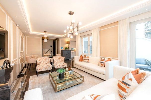 An exceptional three-bedroom, 1,412 sqft apartment arranged across the Ground Floor and Courtyard levels of the building. The apartment entrance features a mirror-fronted storage facility with steps down to the open-plan kitchen and reception space with panel. EPC rating: C. - Photo 1