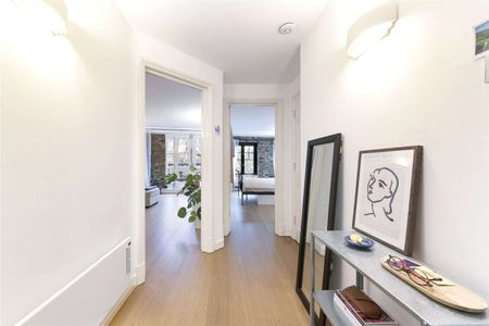 This property benefits from a bright and spacious reception room with exposed brickwork and wooden flooring. - Photo 3