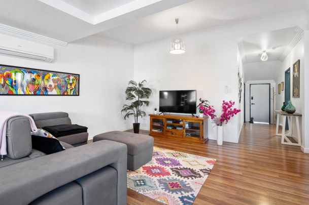 Step inside to discover a blend of modern comfort and timeless charm, featuring polished wooden floorboards and a split system in the spacious lounge area. The large open-plan lounge and dining space - Photo 1
