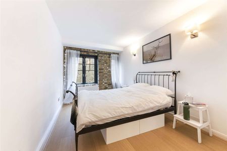 This property benefits from a bright and spacious reception room with exposed brickwork and wooden flooring. - Photo 2