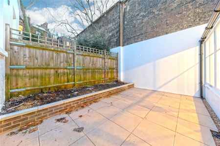 A studio flat boasting a conservatory-style reception room leading to a private patio garden. - Photo 3