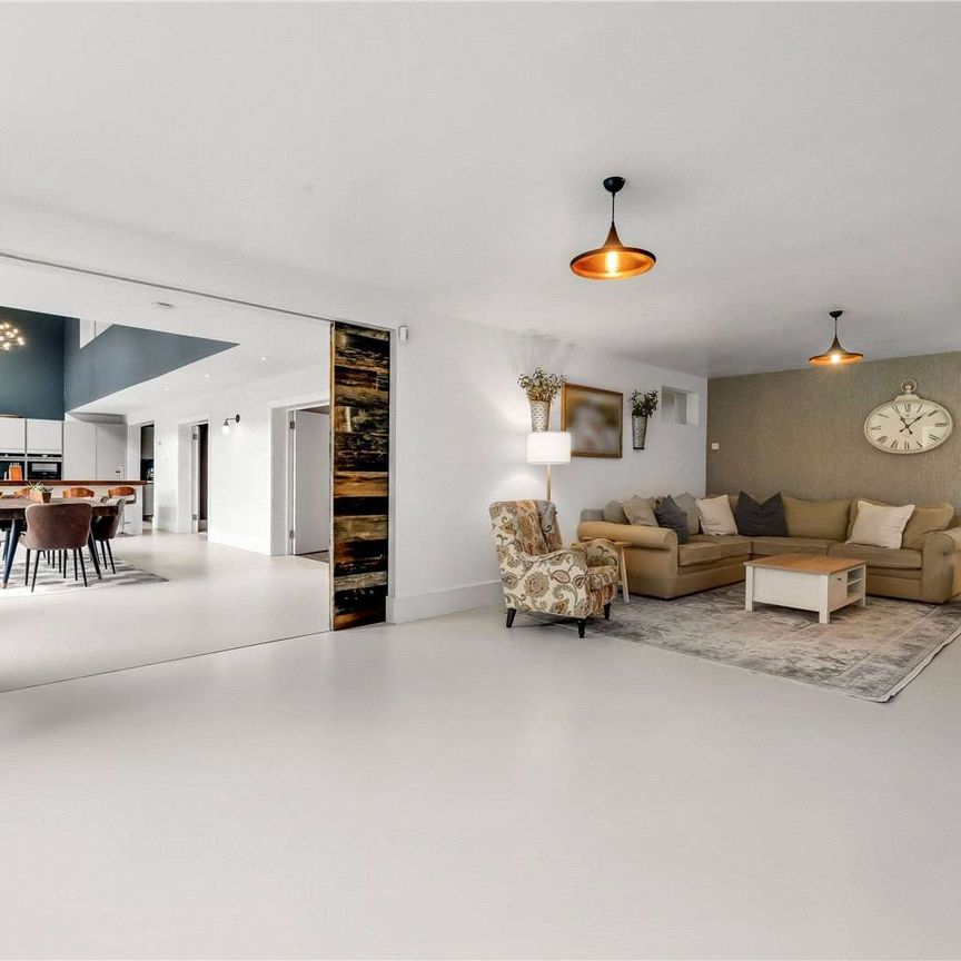 A truly impressive family home in a popular residential road in Esher, offering stylish and modern living with 5 bedrooms, 3 bathrooms and 4 reception areas. - Photo 1