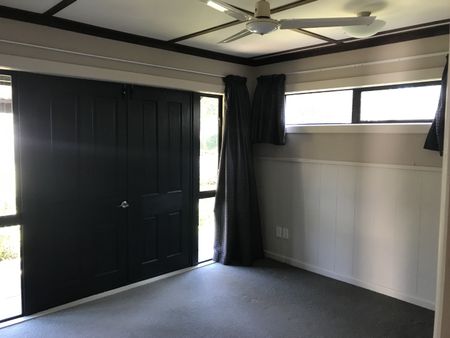 This is a neat and tidy, two bedroom unit at the front of the property, it has open plan kitchen, dining and living with double doors that open out to the deck, a bedroom off either side of the lounge, and the bathroom with shower, toilet and vanity. - Photo 2