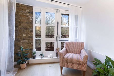 This property benefits from a bright and spacious reception room with exposed brickwork and wooden flooring. - Photo 2
