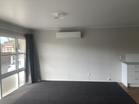 This generous two-bedroom unit offers an open-plan living area, two sizable bedrooms, off-street parking, and a carport. - Photo 2