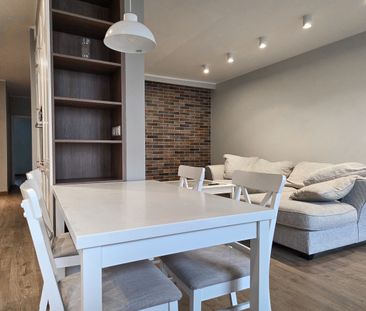 Salon z ceglaną ścianą apartament Maratońska Poznań - Фото 4