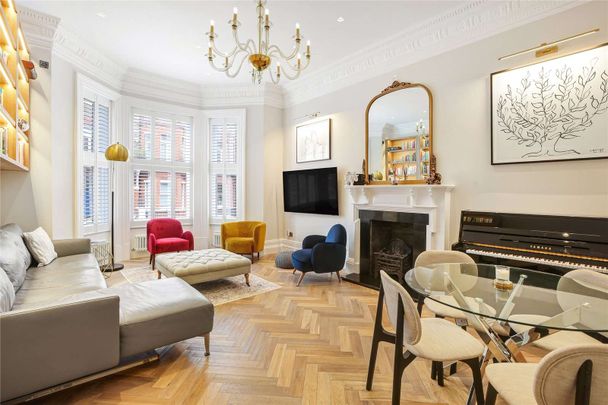 A stunning three-bedroom apartment, situated on the raised ground floor of an impressive red-brick building in South Kensington, benefitting from wooden floors and a private entrance. - Photo 1