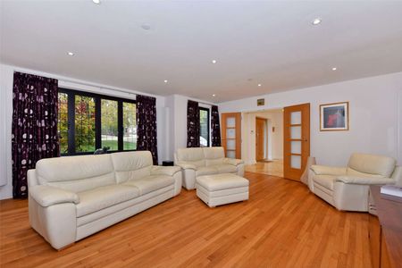 Stunning family home with a beautiful open-plan kitchen and dining area, centred around a striking double-height glass feature wall that floods the space with natural light. - Photo 2