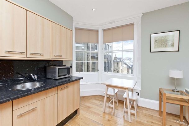 A fantastic furnished flat that is situated in the heart of Edinburgh's historic Old Town, on the edge of the Royal Mile, this desirable flat lies on the first floor of a classical Victorian - Photo 1