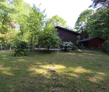 Een weekendverblijf met verdieping en met terras, carport en tuin. - Foto 1