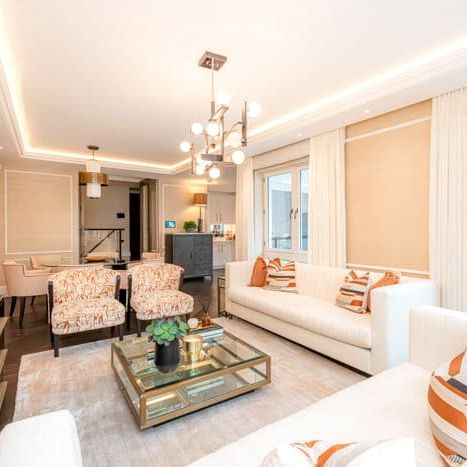 An exceptional three-bedroom, 1,412 sqft apartment arranged across the Ground Floor and Courtyard levels of the building. The apartment entrance features a mirror-fronted storage facility with steps down to the open-plan kitchen and reception space with panel. EPC rating: C. - Photo 1