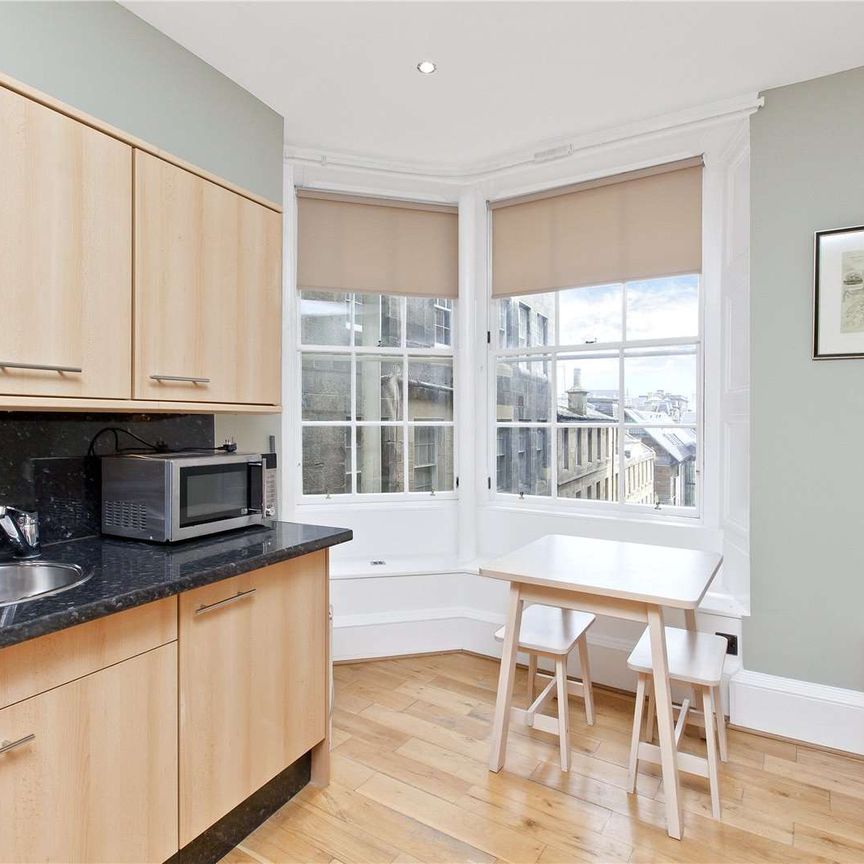 A fantastic furnished flat that is situated in the heart of Edinburgh's historic Old Town, on the edge of the Royal Mile, this desirable flat lies on the first floor of a classical Victorian - Photo 1