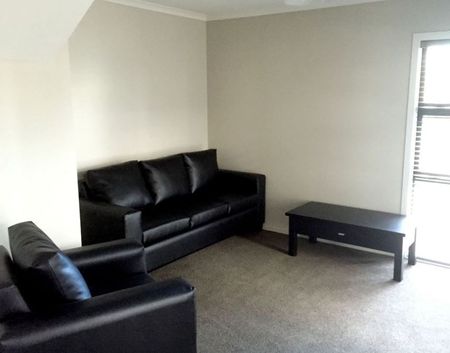 Furnished studio room featuring essential amenities such as a bed, TV, bar fridge, microwave, and heat pump. - Photo 2