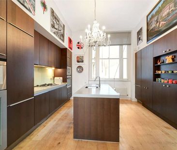 Located in the heart of South Kensington a striking three bedroom period conversion with own entrance, a vast reception room boasting double height ceilings and wooden floors. - Photo 1