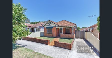 A full brick character home brimming with original charm, offering three spacious bedrooms. - Photo 2